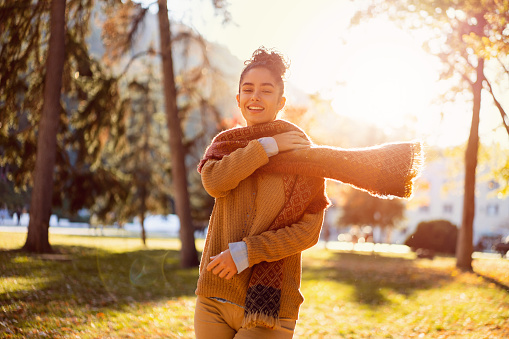 Beautiful young woman enjoying a carefree autumn day outdoors.