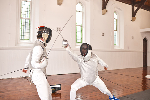 Sport, fight and men with fencing sword in training, exercise or workout in a hall. Martial arts, match and fencers or people with mask and costume for fitness, competition or target in swordplay