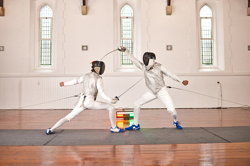 Sword, sport and men fight in fencing training, exercise or workout in a hall. Martial arts, match and fencers or people with mask and costume for fitness, competition or stab target in swordplay
