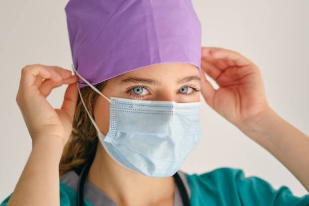istock Woman putting on mask and looking at camera 1605062188