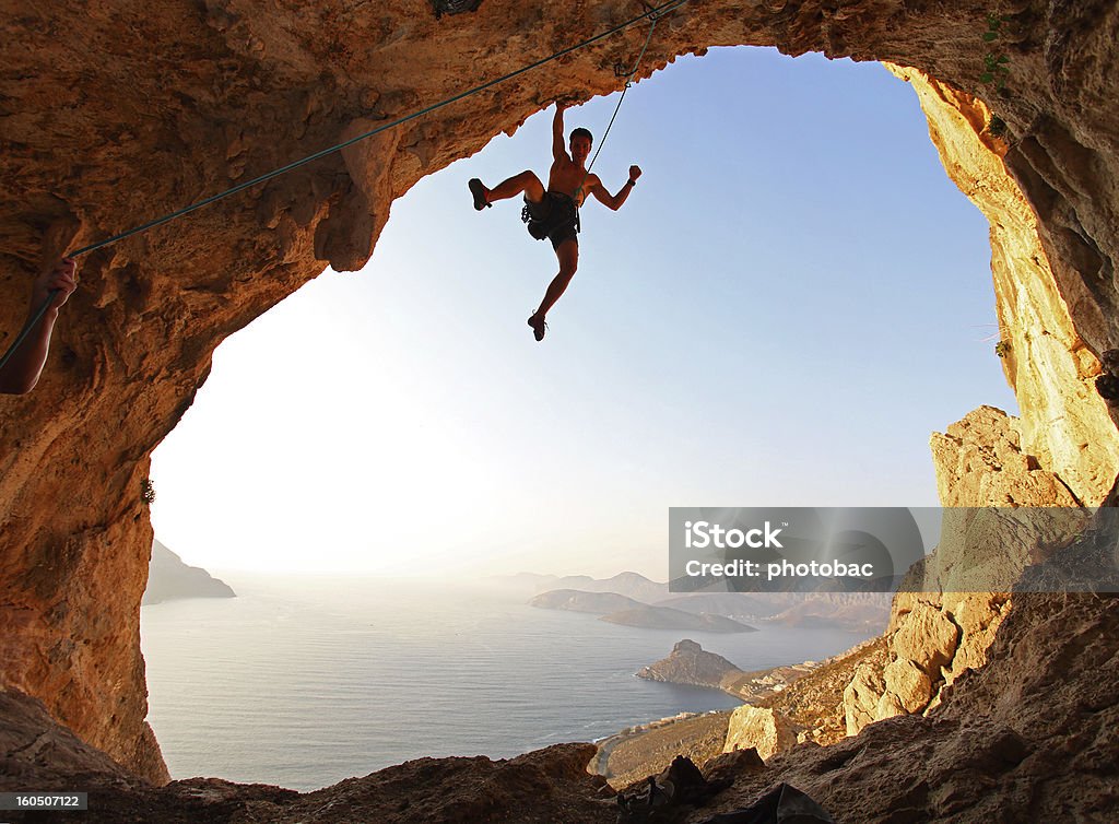 Rock climber at sunset Rock climber at sunset. Kalymnos Island, Greece. Hanging Stock Photo