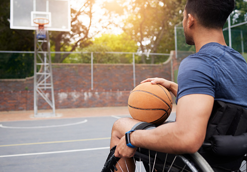 Sports, basketball court and man focus in wheelchair for playing competition, games and shoot outdoors. Fitness, wellness and male person with disability with ball for training, workout and exercise