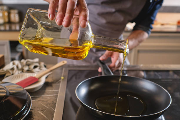 istock Unrecognizable man pouring oil into frying pan 1605100378