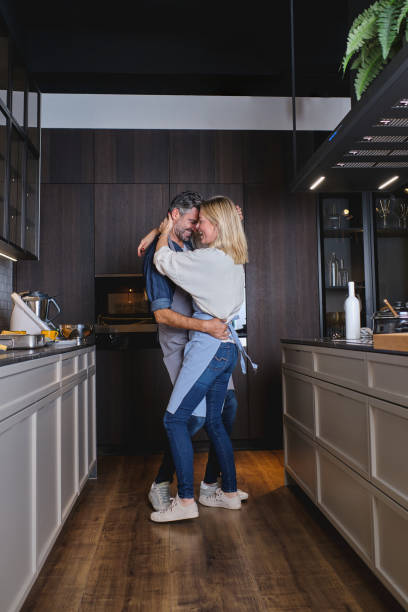istock Couple in love embracing and dancing in kitchen 1605108589