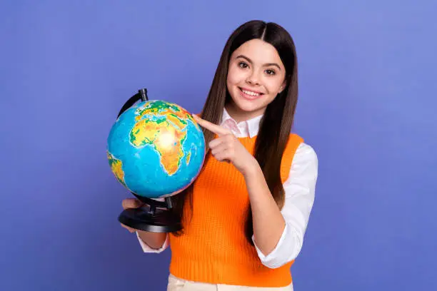 Photo of intelligent person schoolgirl clever teacher directing finger earth globe planet show continent isolated on violet color background.