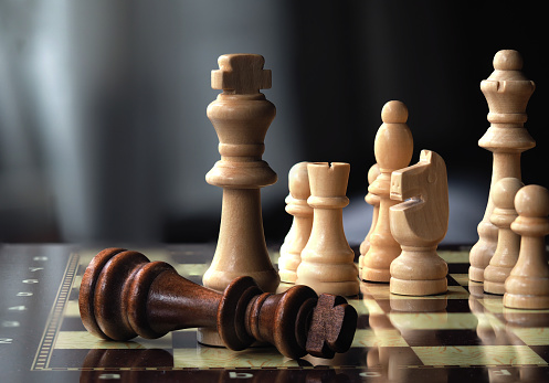 Chessboard and pieces in front of grey background