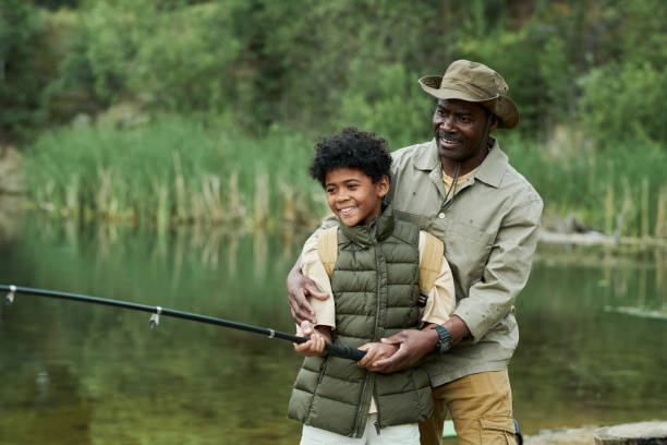 istock Dad catching fish together with his son 1605122153
