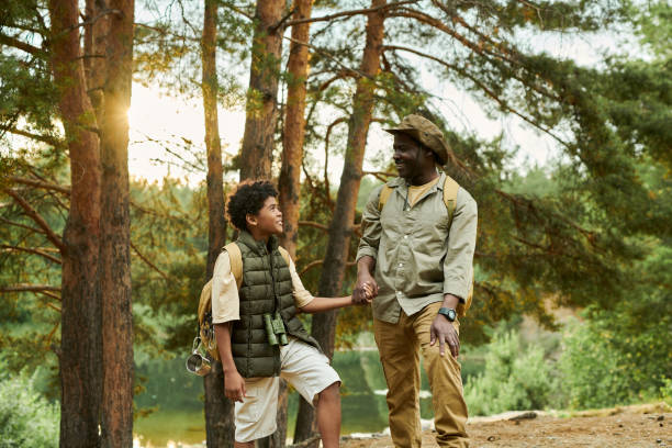 istock Dad with son hiking in the forest 1605125504