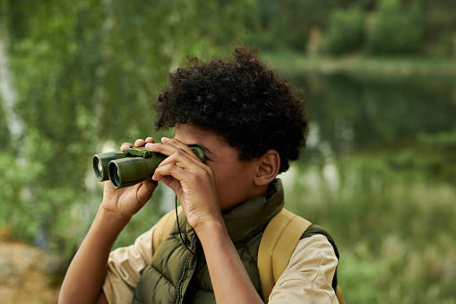 African American child using binoculars during hiking