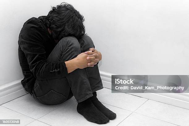 A Man In Black Huddled In A Corner Stock Photo - Download Image Now - Fetal Position, Only Men, One Person