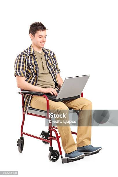 Joven Hombre Discapacitado En Silla De Ruedas Trabajando En La Computadora Portátil Foto de stock y más banco de imágenes de Adolescencia