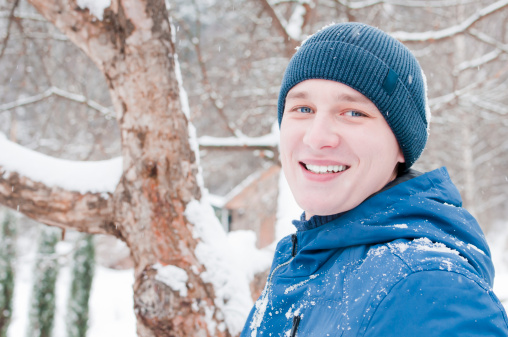 Young Handsome Man In Winter. Portrait on the background of the winter forest