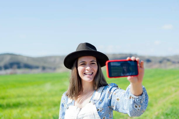 istock Brunette woman posing outdoors, taking self portrait 1605144217