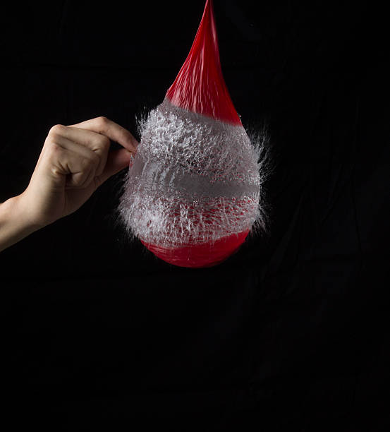 High Speed Balloon Freeze Action photography of water balloon being popped by needle. water balloon stock pictures, royalty-free photos & images