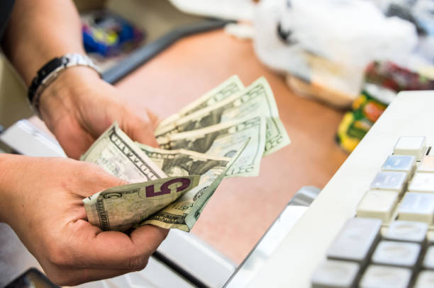 Store cashier counting the cash Convenient store female cashier counting the cash at the counter liquor store counter photos stock pictures, royalty-free photos & images