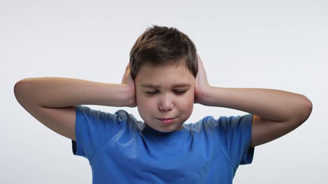 Boy closes ears with his hands