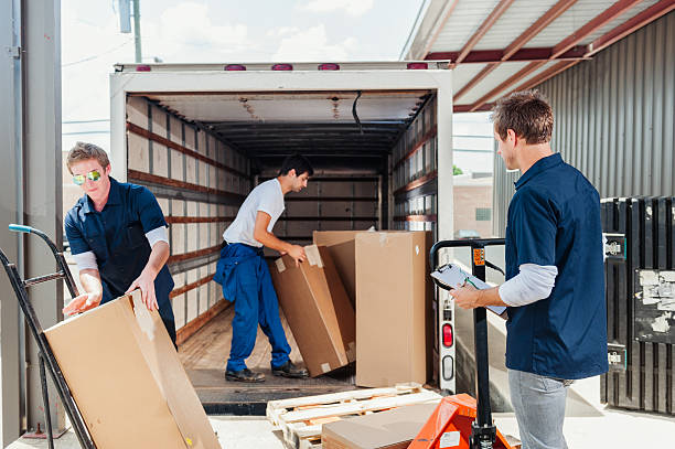 A group of dock workers are loading a delivery truck stock photo