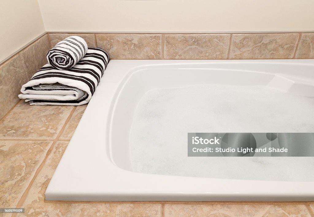 Listrado toalhas dobradas e banheira com espuma - Foto de stock de Algodão - Material Têxtil royalty-free