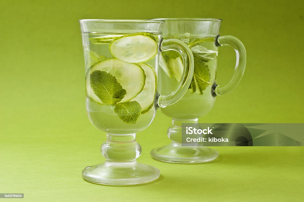 refreshing water with cucumber refreshing water with cucumber and mint in glass over green background Cold Drink Stock Photo