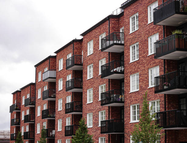 istock Low angle view of apartment building against cloudy sky 1605206238
