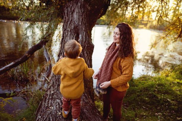 istock Mother helping her son to climb a tree 1605214030