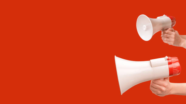 istock Megaphone in woman hands on a red background. 1605214967
