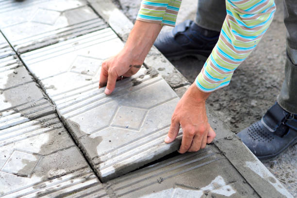 istock Worker tiler lays tiles with cement outside on summer day. Authentic workflow. Hands with facing tiles 1605216146
