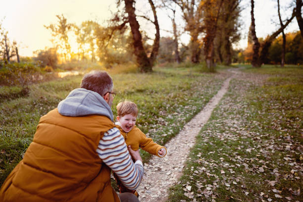 istock Little boy running into father's arms 1605217794