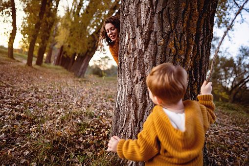 Mother and son playing hide and seek at a park.