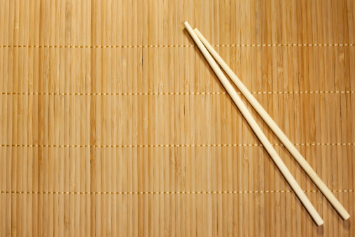 Bamboo yellow mat and chopsticks food background concept