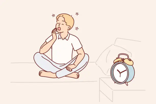 Vector illustration of Boy yawns and wants to sleep sitting on bed near alarm clock and feels morning sleepiness
