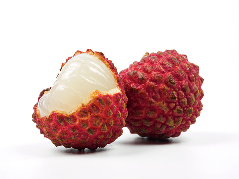 Lychee or litchi fruits in wooden bowl. Unpeeled ripe red Litchi chinensis, also called liechee, liche, lizhi or li zhi. Isolated macro food photo close up from above on white background.