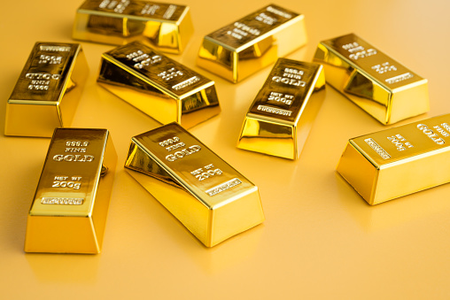Gold bars or bullion on yellow background. Financial, global world economic or gold trading in commodity market concept. It performs well during global crises.