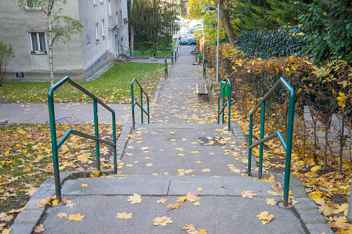 autumn street with yellow leaves and benches in the old city. stairs in the city park