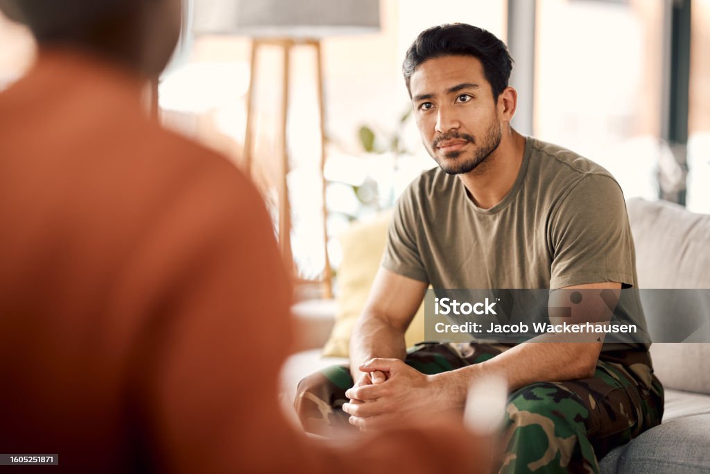 Listen, therapy and a military man with a psychologist for counselling, support and psychology. Young army, veteran or soldier person on therapist couch for mental health, consultation or help Mental Health Stock Photo