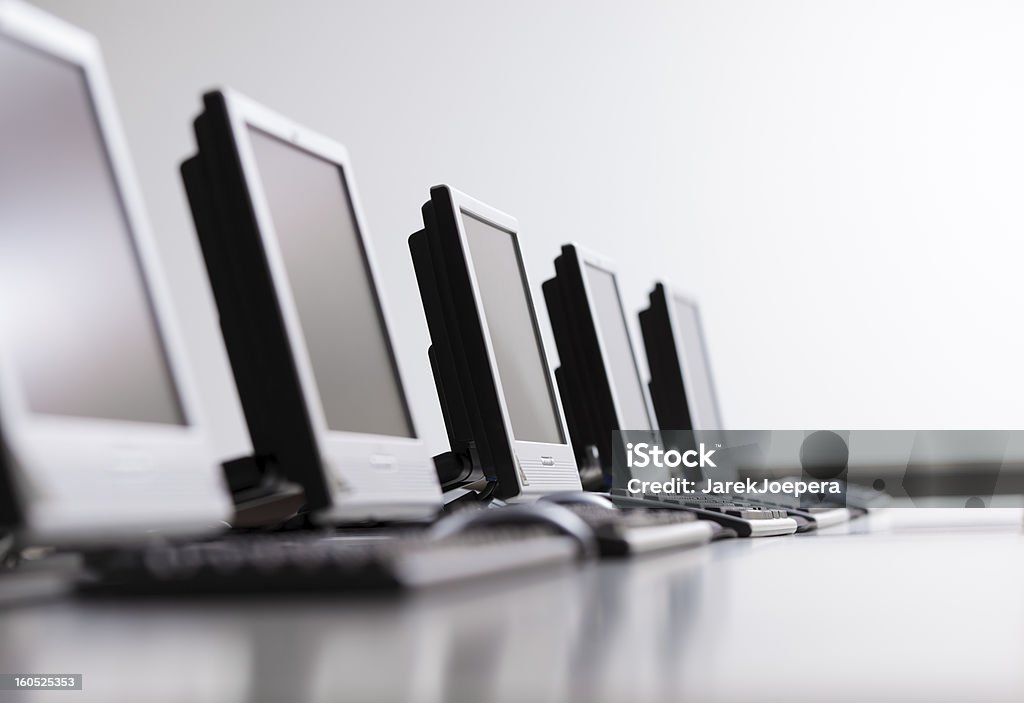 Workplaces in a row Desktop computers in a row. Modern classroom table with computers. Computer Stock Photo