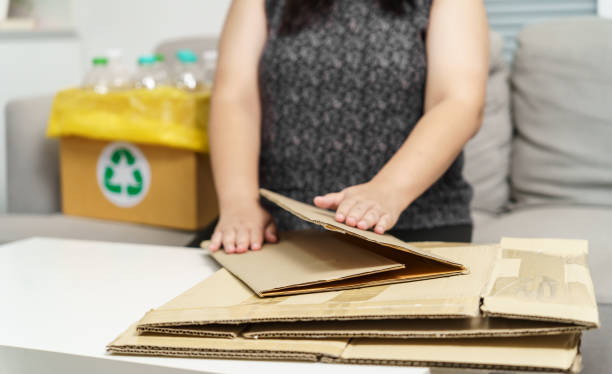 istock Home recycle eco zero waste concept Woman using recycle paper box. Stacking brown cardboard box eco friendly packaging made of recyclable raw materials. 1605255146