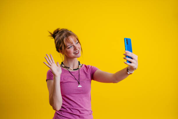 istock Young Woman Having A Video Calll Against A Yellow Background 1605264534