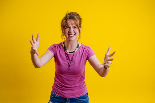 istock Angry Young Woman Standing Against A Yellow Background 1605265387