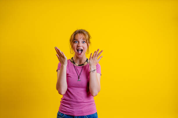 istock Surprised Young Woman Standing Against A Yellow Background 1605270167