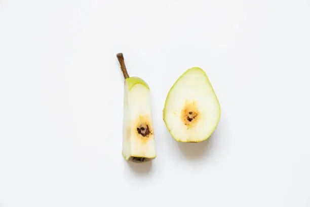 Photo of Sliced pear with a worm on a white background