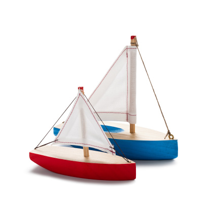 Red and blue toy sailboats, isolated on white.