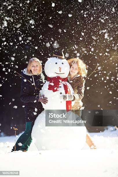 Due Giovani Donne Abbracciare Pupazzo Di Neve - Fotografie stock e altre immagini di Abbigliamento casual - Abbigliamento casual, Abbracciare una persona, Adolescente