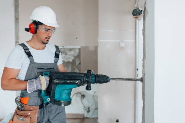 istock Worker making strategic hole in apartment wall 1605284814