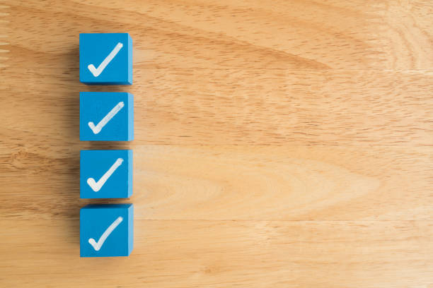 Check mark sign on blue block checklist wooden background copy space. Checklist and questionnaire in business, education concept.