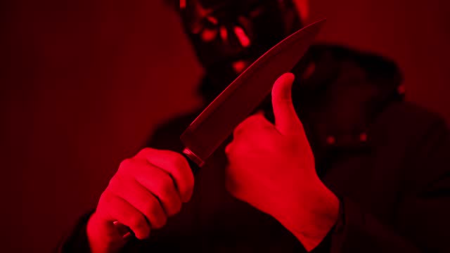 Scary Man Wearing A Black Mask And Holding A Knife