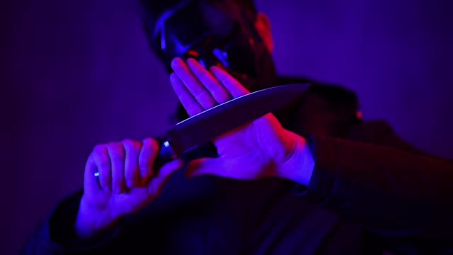 Scary Man Wearing A Black Mask And Holding A Knife