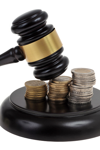 Judge gavel and stacks of euro coins close up on white background