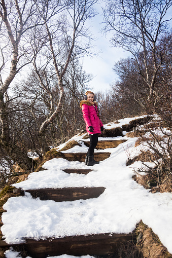 A young woman posing in Skaftafell National Park view during winter snow which located in Vatnajokull Iceland that lead to Kristinartindar Mountain and Svartifoss waterfall.