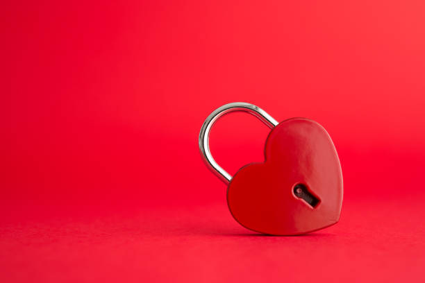 istock Love red heart shape padlock on red background with copy space. 1605325971